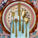 Earthtone place setting featuring gold flatware