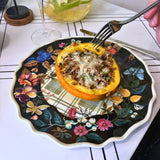 Stuffed squash on a black floral dinner plate.
