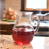 Glass pitcher full of red punch.