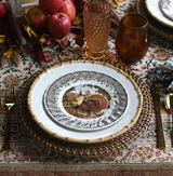 A Thanksgiving place setting featuring a bamboo rimmed dinner plate with a turkey salad plate.