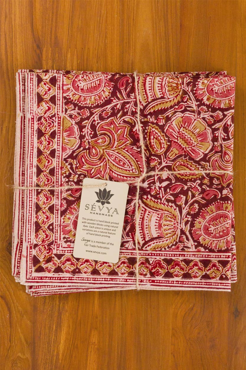 Stack of patterned napkins with a visible brand tag on a wooden surface