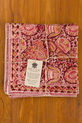 Stack of patterned napkins with a visible brand tag on a wooden surface