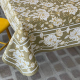 Floral patterned tablecloth on a table with a chair partially visible.