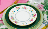Steeplechase Collection - Light green charger plate, dark green dinner plate, salad plate with roses on rim, and gold-luster flatware.