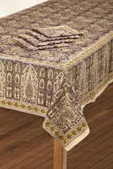 Decorative tablecloth with intricate patterns on a wooden table.