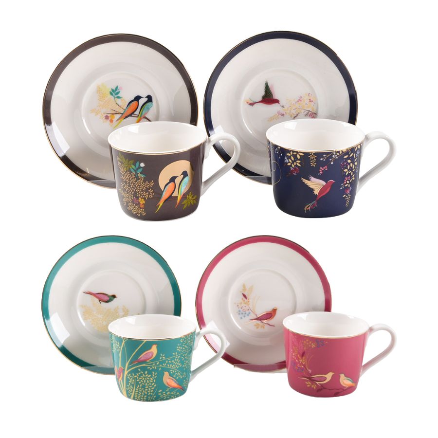 Set of ceramic cups and saucers with bird designs on a white background
