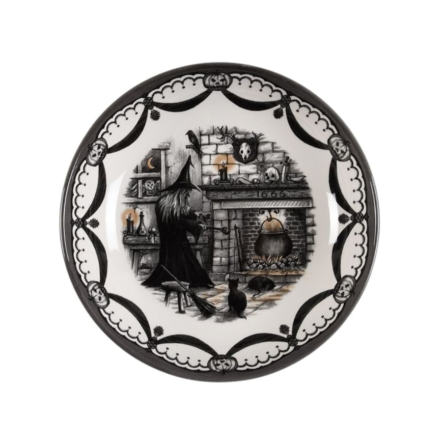 Decorative plate with a witch and cat design on a white background