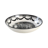 Decorative bowl with black scalloped rim and black and white witch scene.