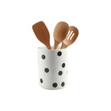 Wooden spoons in a white utensil holder with black polka dots.
