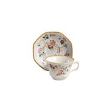 Ceramic cup and saucer set with floral design on a white background