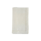 Warm white linen napkins with hemstitching folded on a white background.