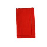 Folded red linen napkins with hemstitching on a white background.