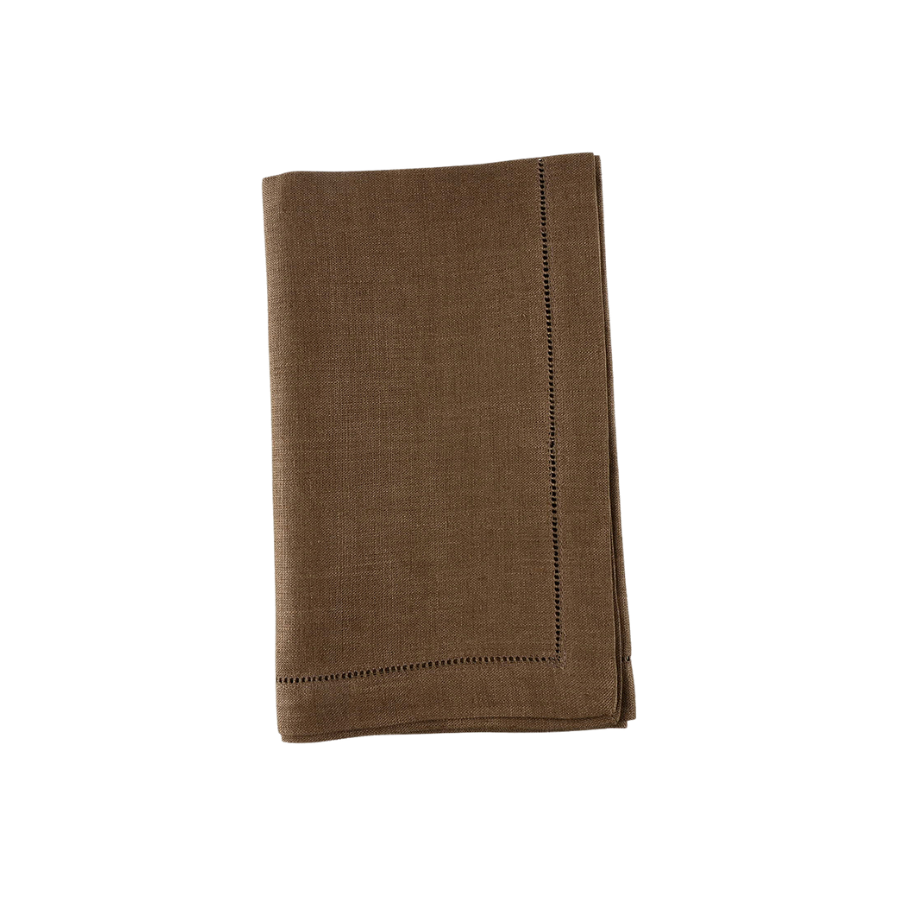 Folded brown linen napkin with hemstitching on a white background.
