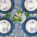 Blue Garden Table Setting Collection. Greek pattern-edged charger plate topped with white salad plate with decorative blue flowers in Chinese art style and gold rimmed edges.