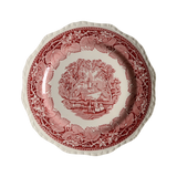 Decorative plate featuring a countryside scene in a leafy floral border.