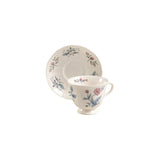 Embossed teacup decorated with muted floral designs.