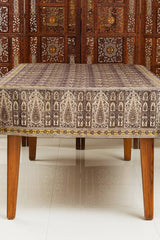 Decorative tablecloth with intricate patterns on a wooden table against a wooden panel background